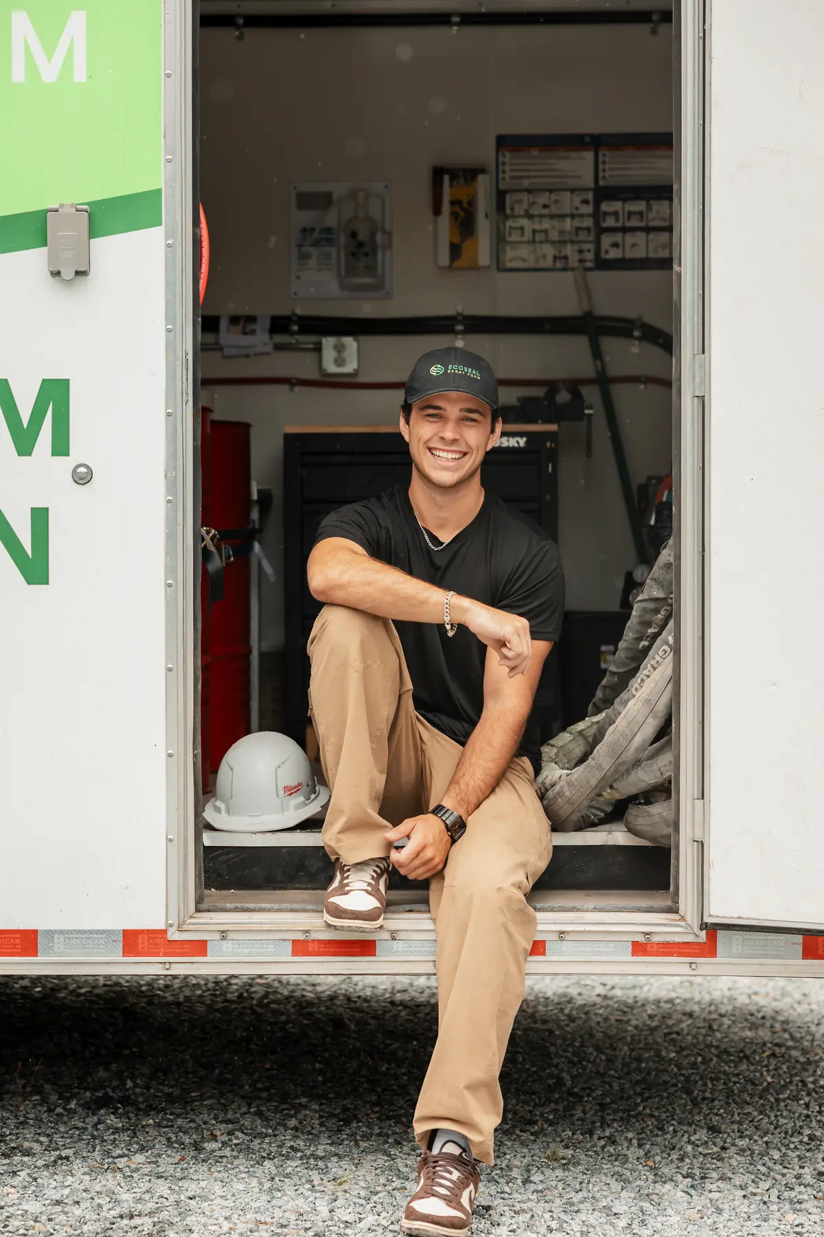 Jacob McCardell, owner of EcoSeal Building Performance Systems, sitting in the doorway of his EcoSeal spray foam trailer.